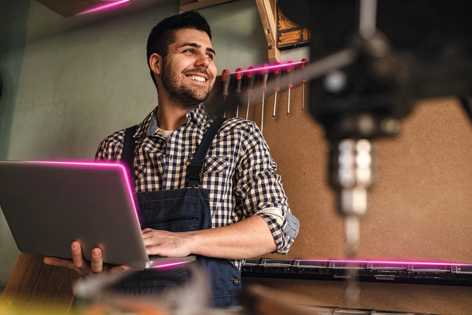 Bild eines Mannes, der vor einer Maschine steht und etwas in seinen Laptop eingibt
